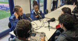 Élèves en activité, interviewant deux jeunes joueuses du centre de formation du club de football féminin Paris FC dans le cadre d'un projet de réalisation de podcast