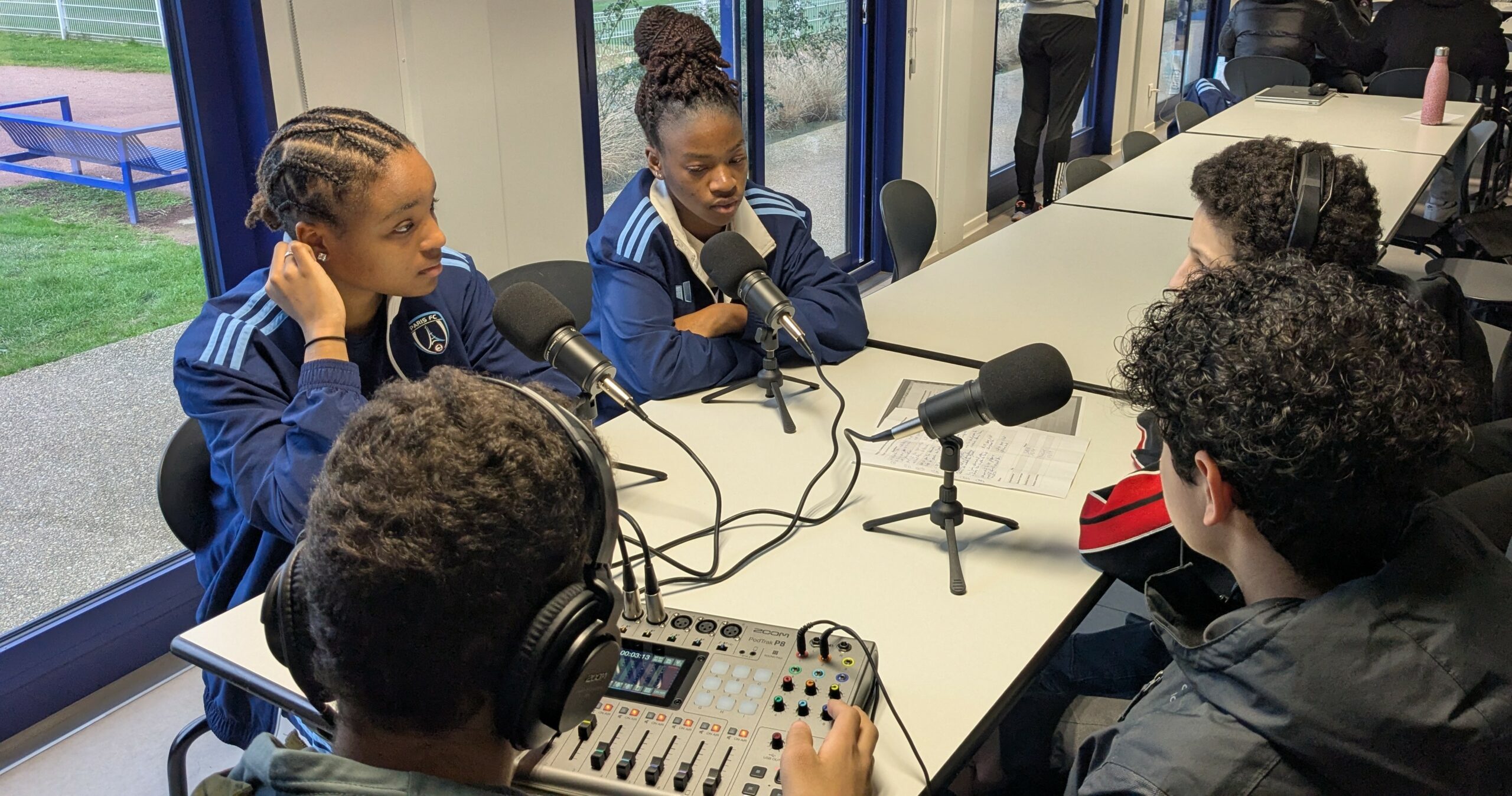 Élèves en activité, interviewant deux jeunes joueuses du centre de formation du club de football féminin Paris FC dans le cadre d'un projet de réalisation de podcast